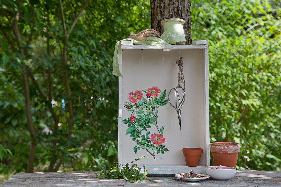 Shelf unit made from old wooden crate and decorated with wild-rose motif