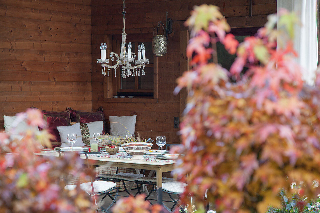 Set table below chandelier in autumnal ambiance