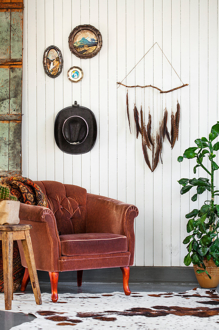 Brauner Sessel, darüber DIY-Dekoration an weiß gestrichener Holzwand