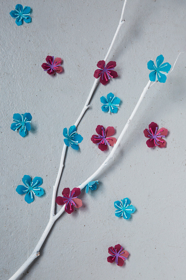 Zweige mit Papierblüten dekoriert