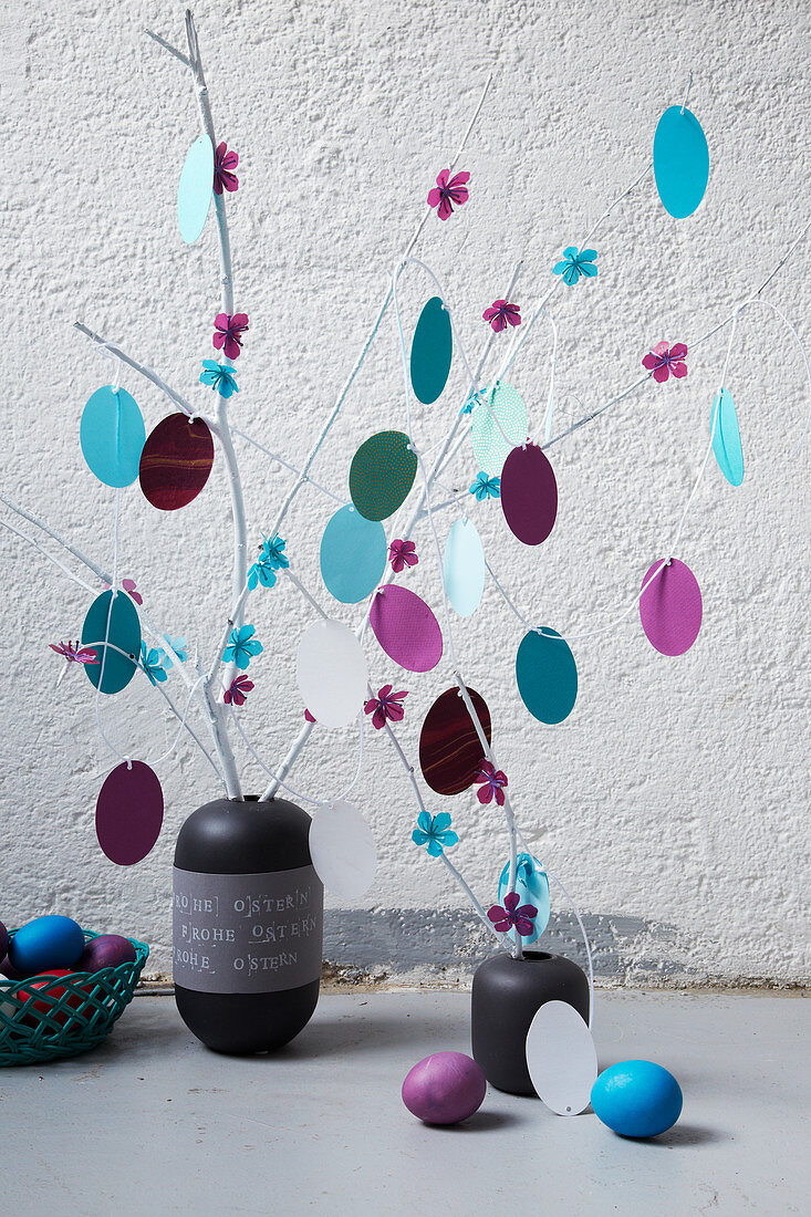 Vase of branches decorated with paper flowers and paper Easter eggs