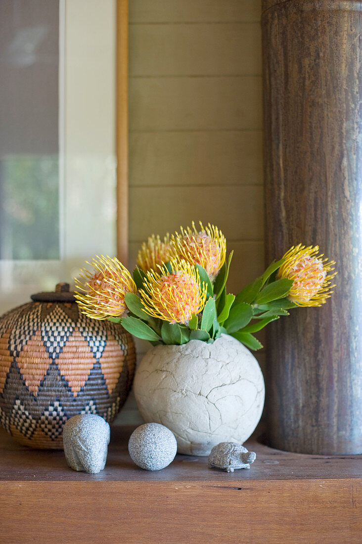 Protea flowers in rustic spherical vase
