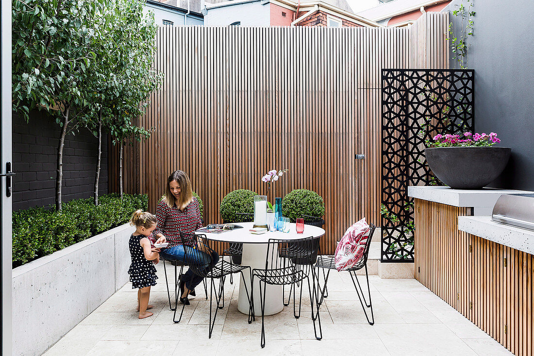 Mother and daughter on the courtyard terrace with outdoor kitchen