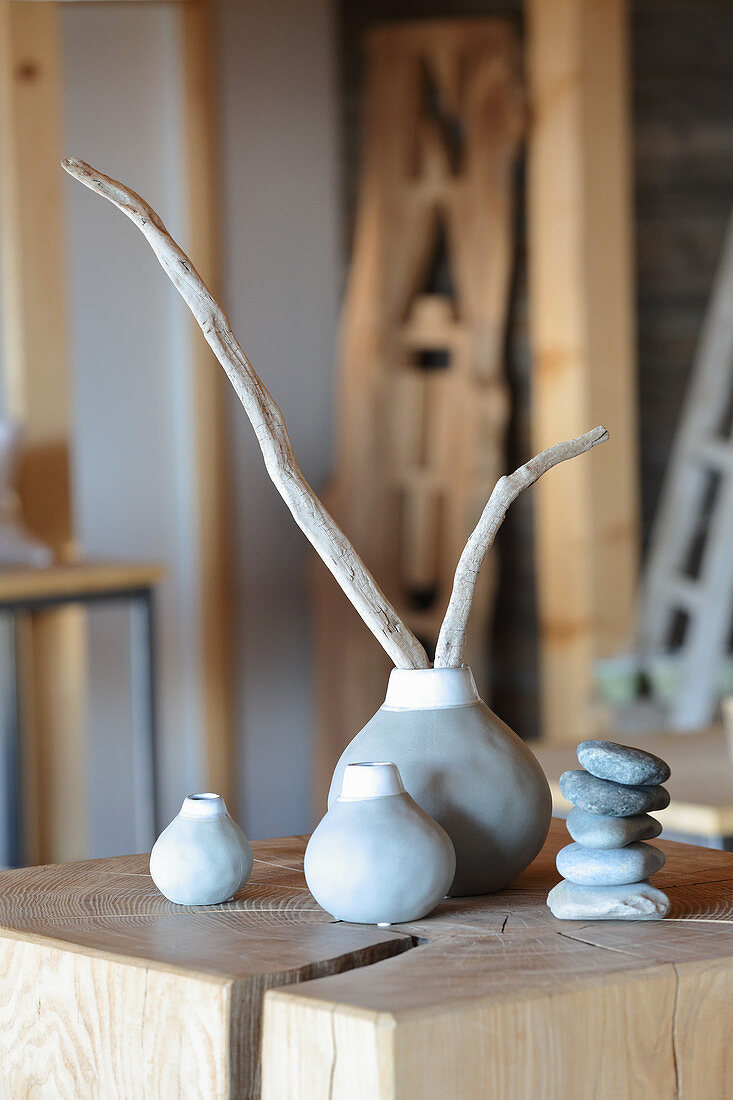 Schwemmhölzer in schlichten weiß-grauen Vasen