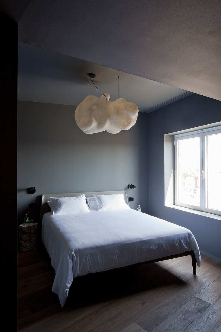 Designerlampe über Doppelbett im Schlafzimmer
