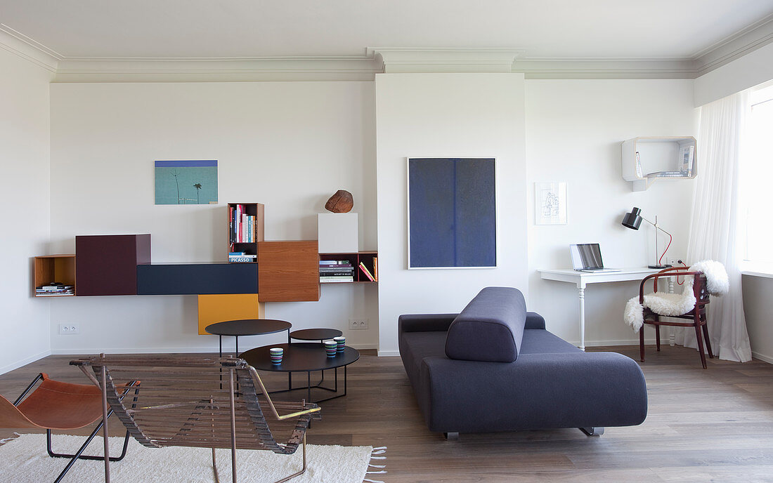 Designermöbel und Arbeitsecke im Wohnzimmer mit weißer Wand