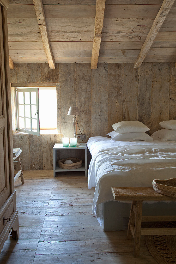 Rustic bedroom with wooden walls, floor and ceiling
