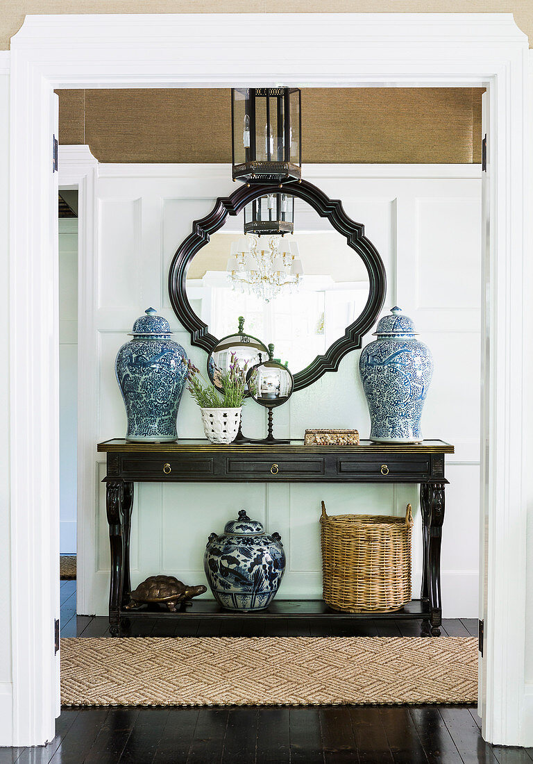 Console table with Asian vases against a cassette wall