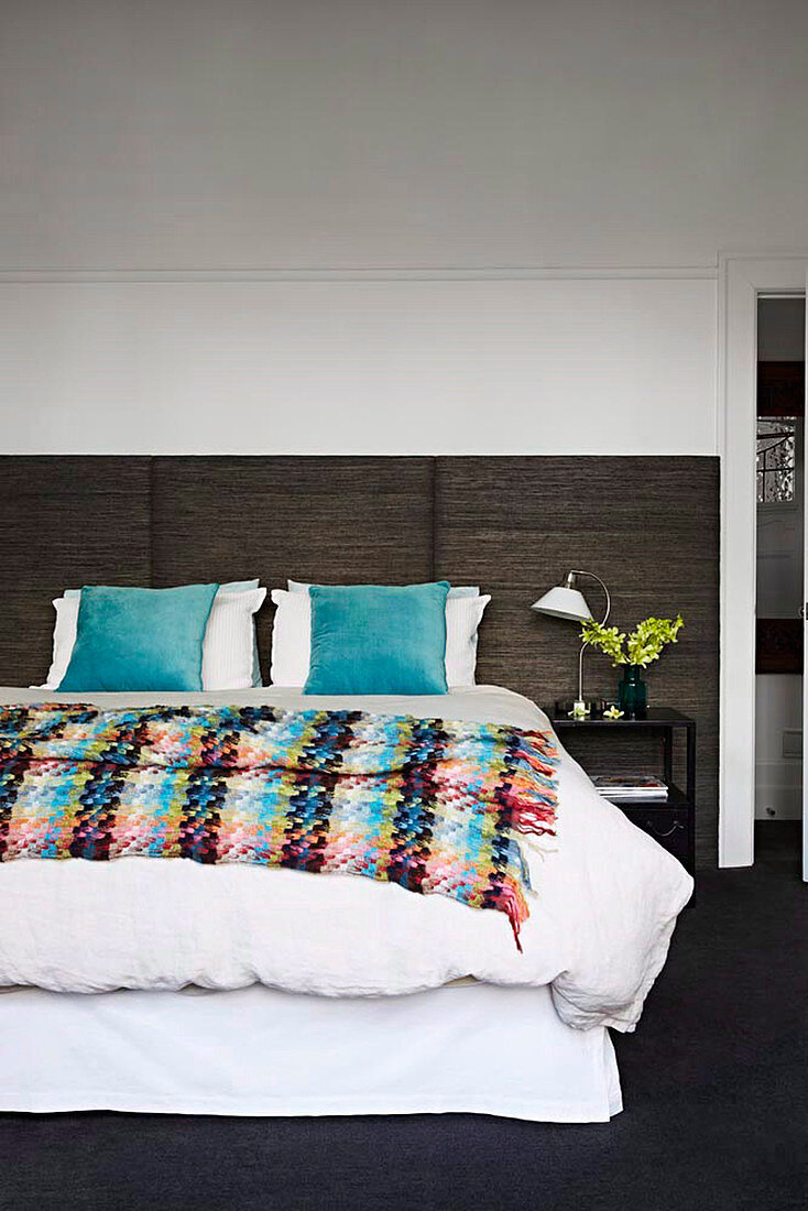 Double bed with colorful bedspread in the bedroom