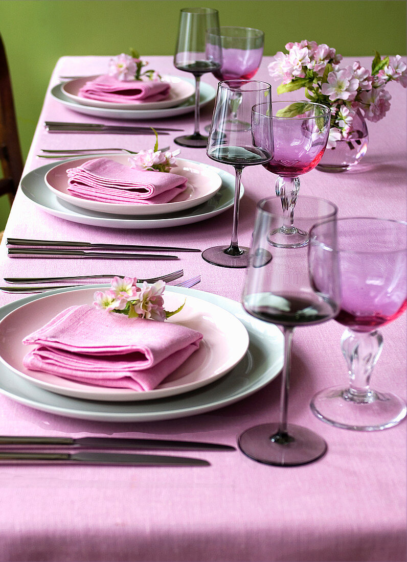 Gedeckter Esstisch mit pinkem Tischtuch und Stoffservietten