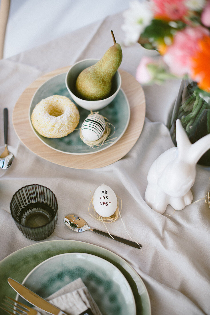 Table decorated in casual style for Easter breakfast with lettering on egg