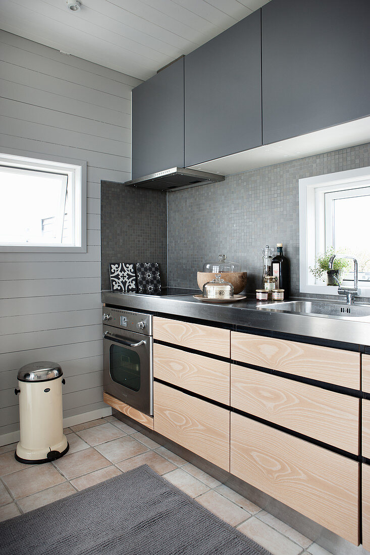 Küchenzeile mit hellen Holzfronten und grauen Oberschränken