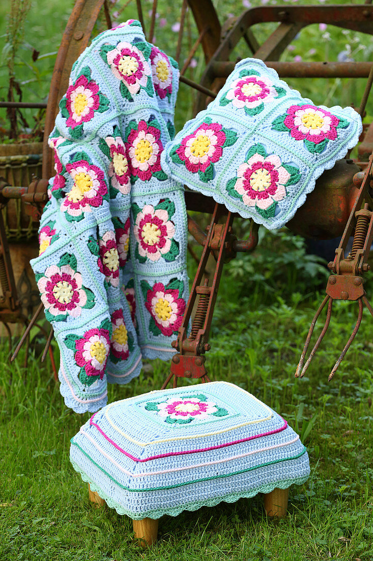 Crocheted blanket, cushion and footstool with floral motifs