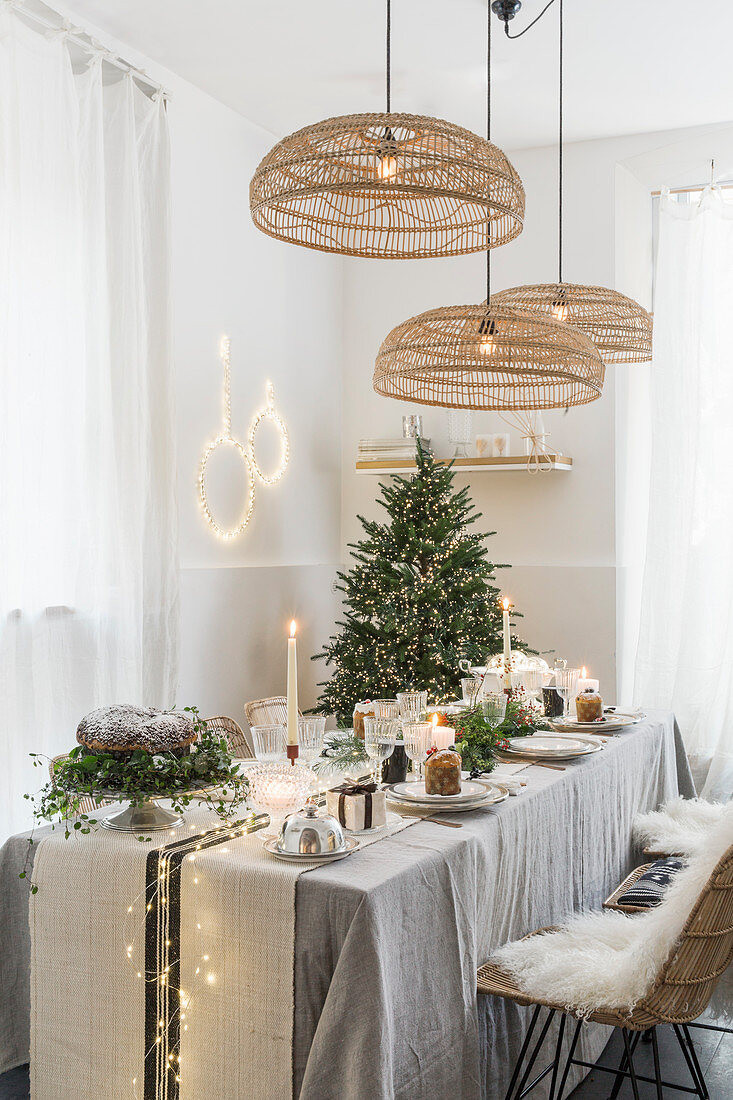 Korb-Leuchten überm weihnachtlich gedeckten Tisch in Naturtönen