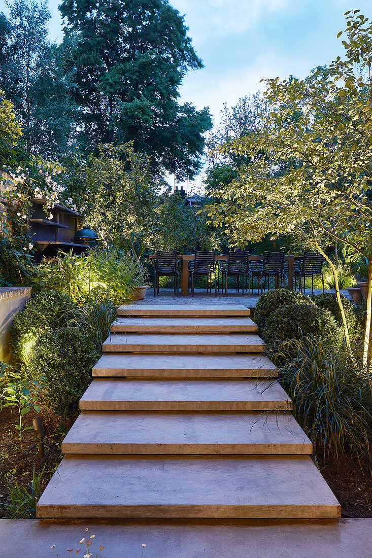 Steps leading to terrace in split-level garden at twilight