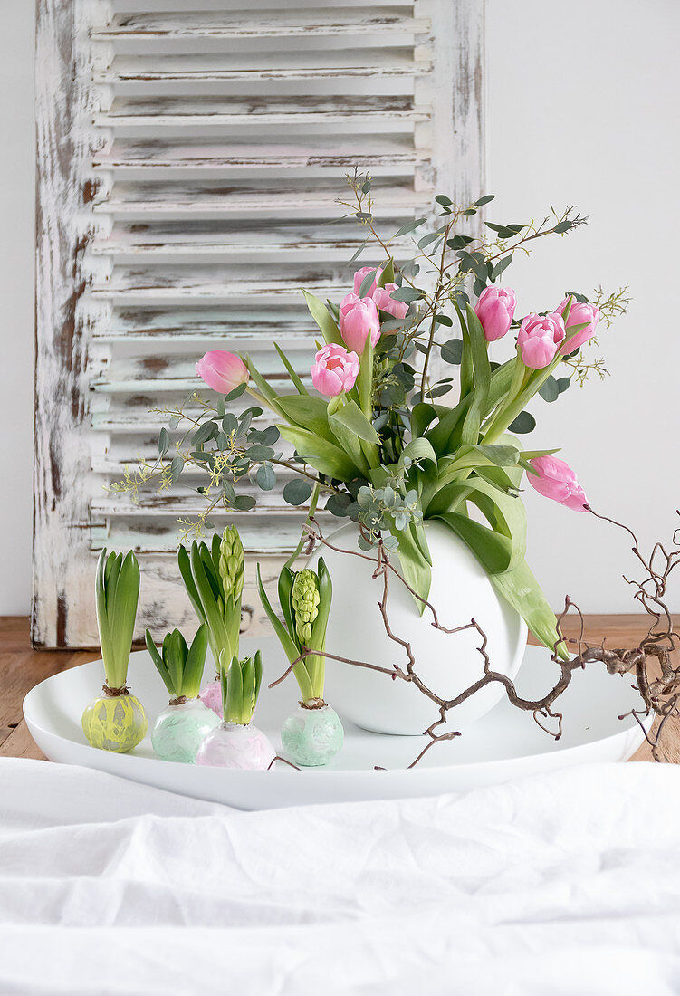 Tulpenstrauß in Kugelvase und Hyazinthen mit gewachsten Blumenzwiebeln als Frühlingsdeko