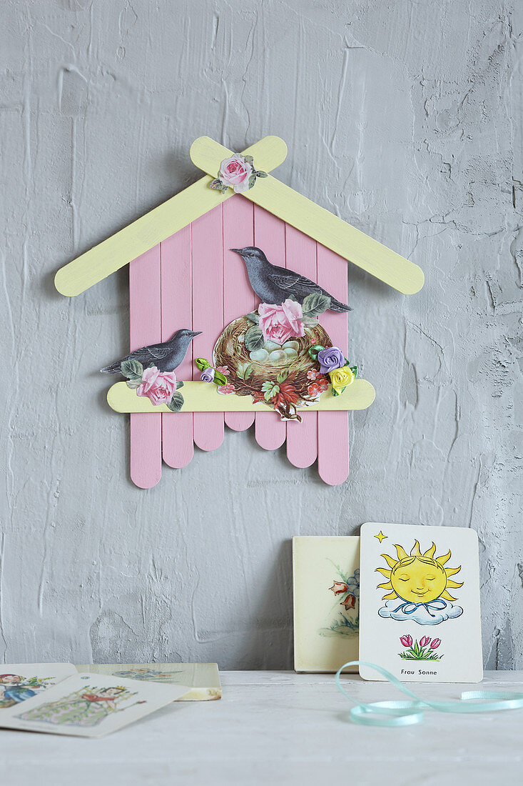 Birdhouse decoration made from painted lolly sticks and scrapbook pictures