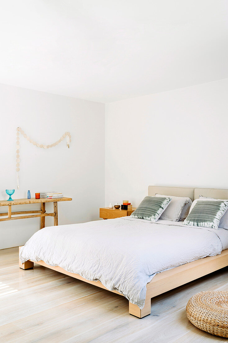 Doppelbett aus Massivholz und Konsole in weißem Schlafzimmer