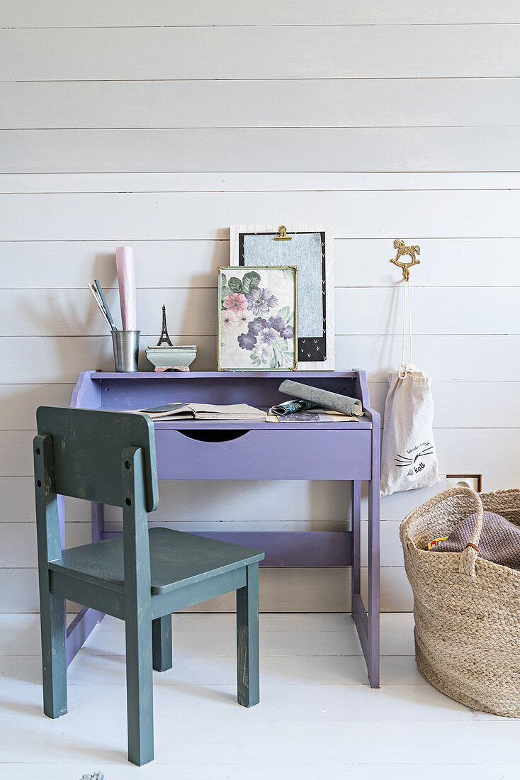 Child's chair at purple desk below sloping ceiling