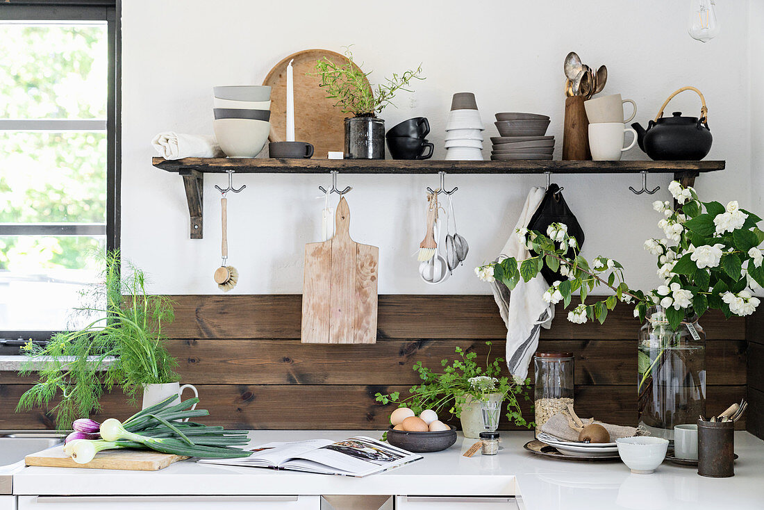 Regal mit rustikalem Geschirr in der Küche mit Holzverkleidung