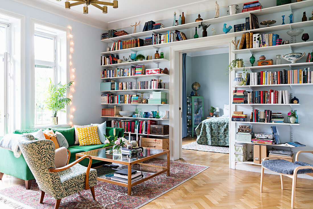Living room with floor-to-ceiling shelves filled with books and ornaments