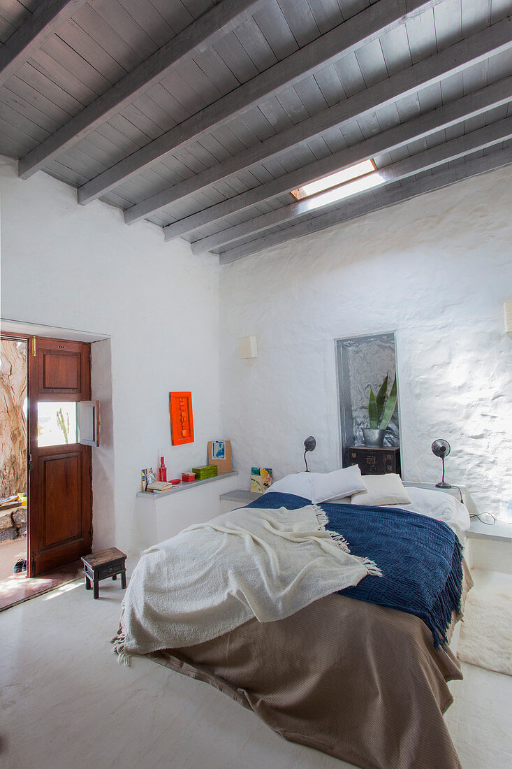 Doppelbett in hohem, weiß gestrichenem Schlafzimmer
