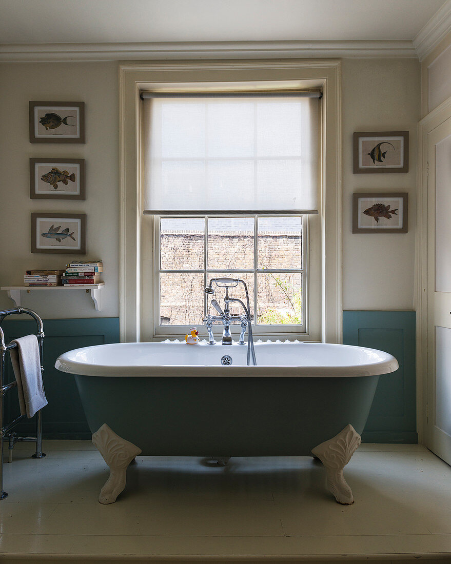 Free-standing, claw-footed blue bathtub in bathroom of period building