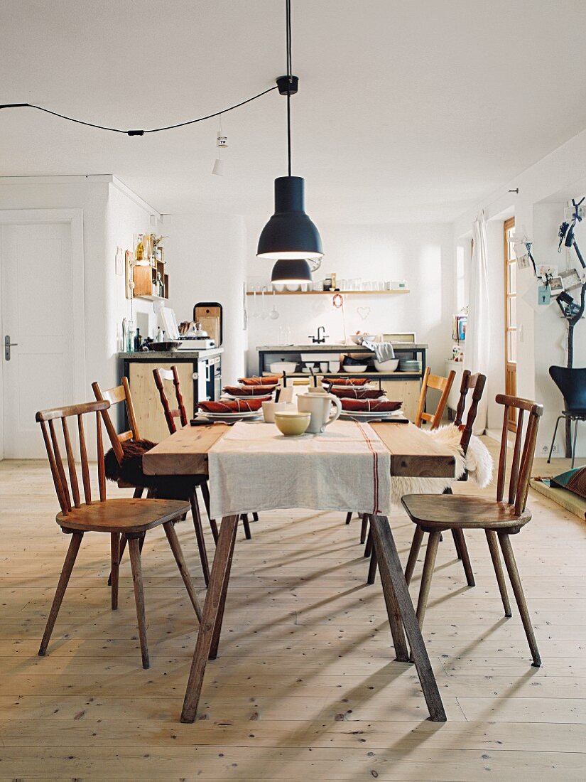 A rustic dining table with wooden chairs in a rural-style kitchen