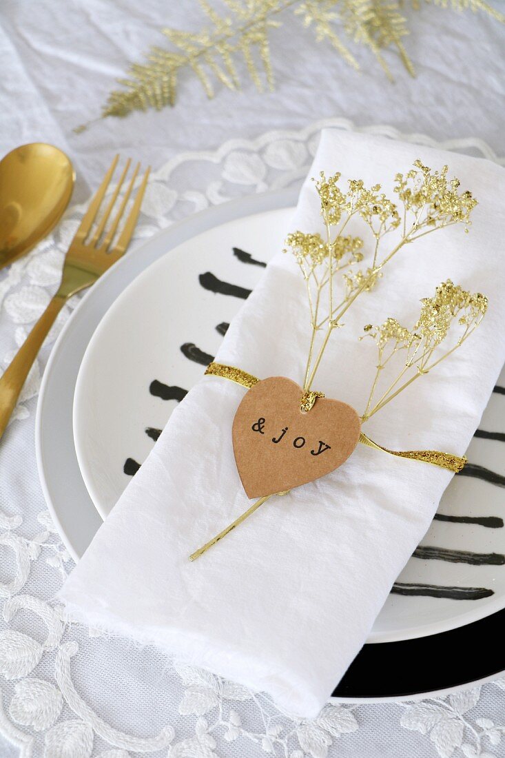 Heart-shaped tag and dried flower sprayed gold on napkin