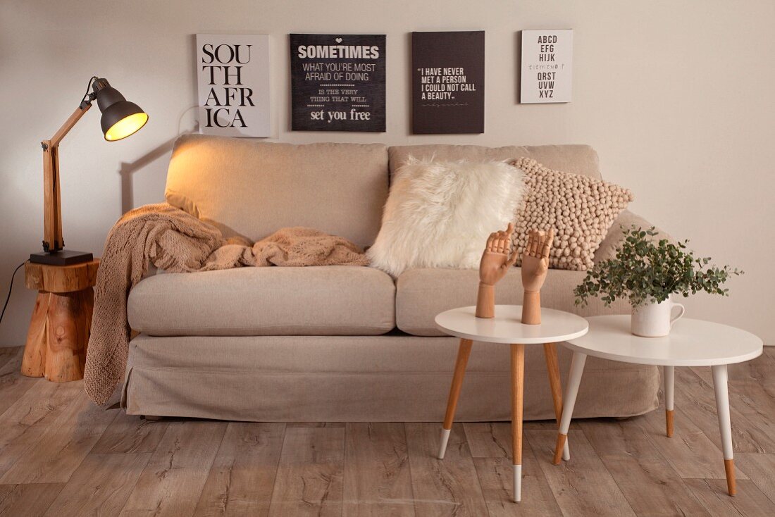 Wohnzimmer in Beige und Weiß mit Grafikprints über dem Sofa