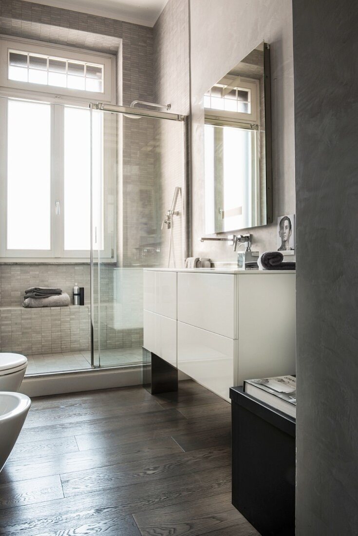Modernes Badezimmer in Grautönen mit Dusche vor dem Fenster