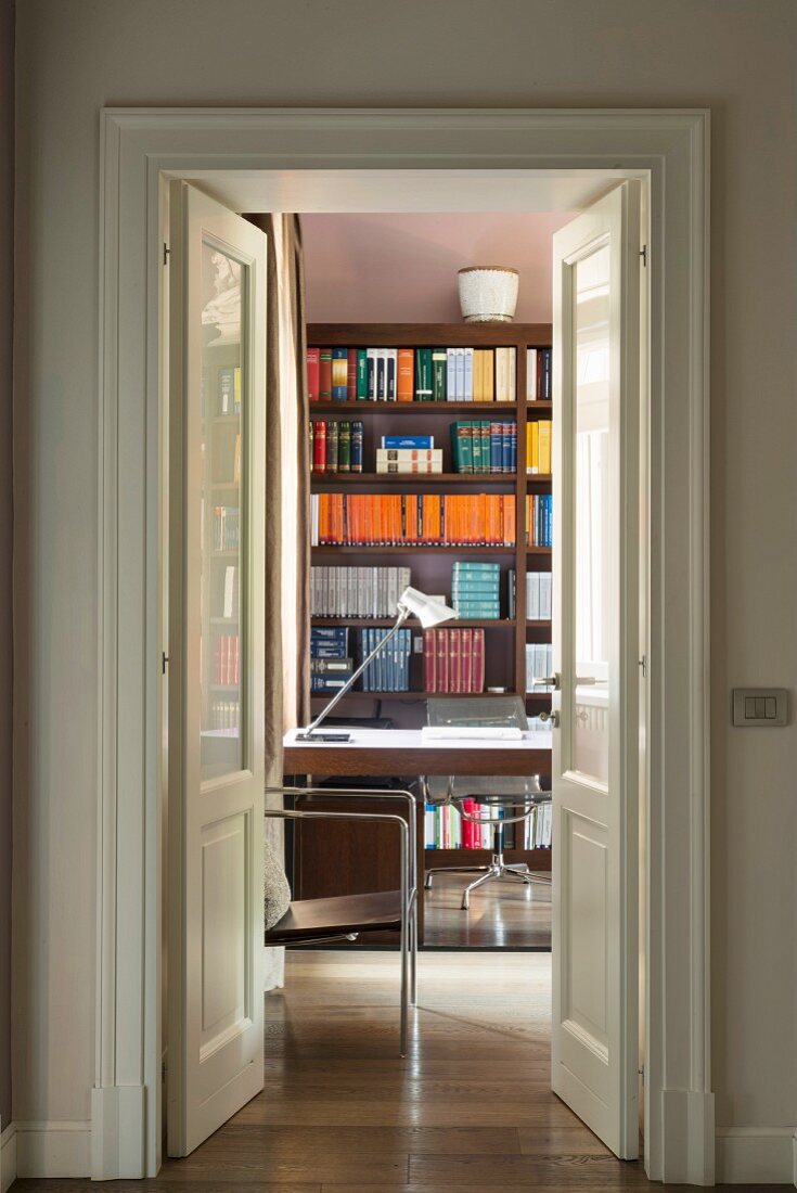 Blick durch offene Doppeltür ins Arbeitszimmer mit Bücherregal