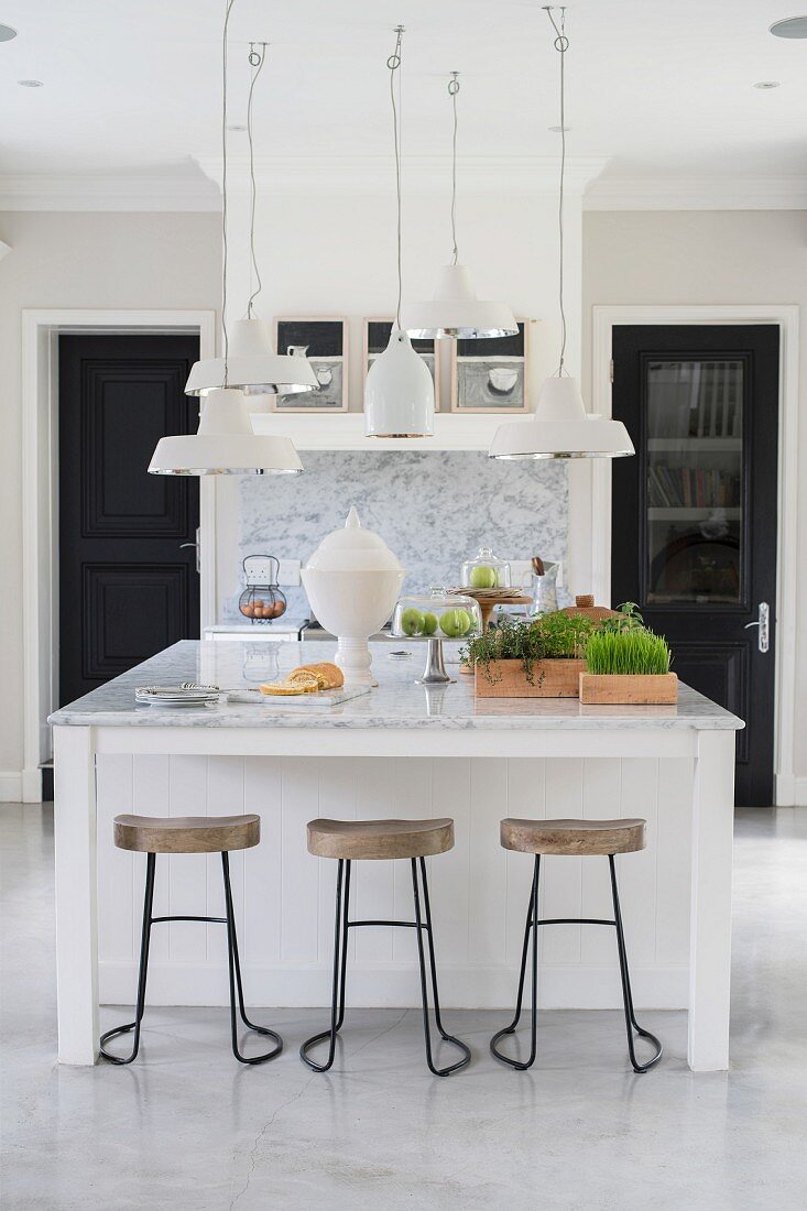 Group of ceiling lamps above island counter with marble top
