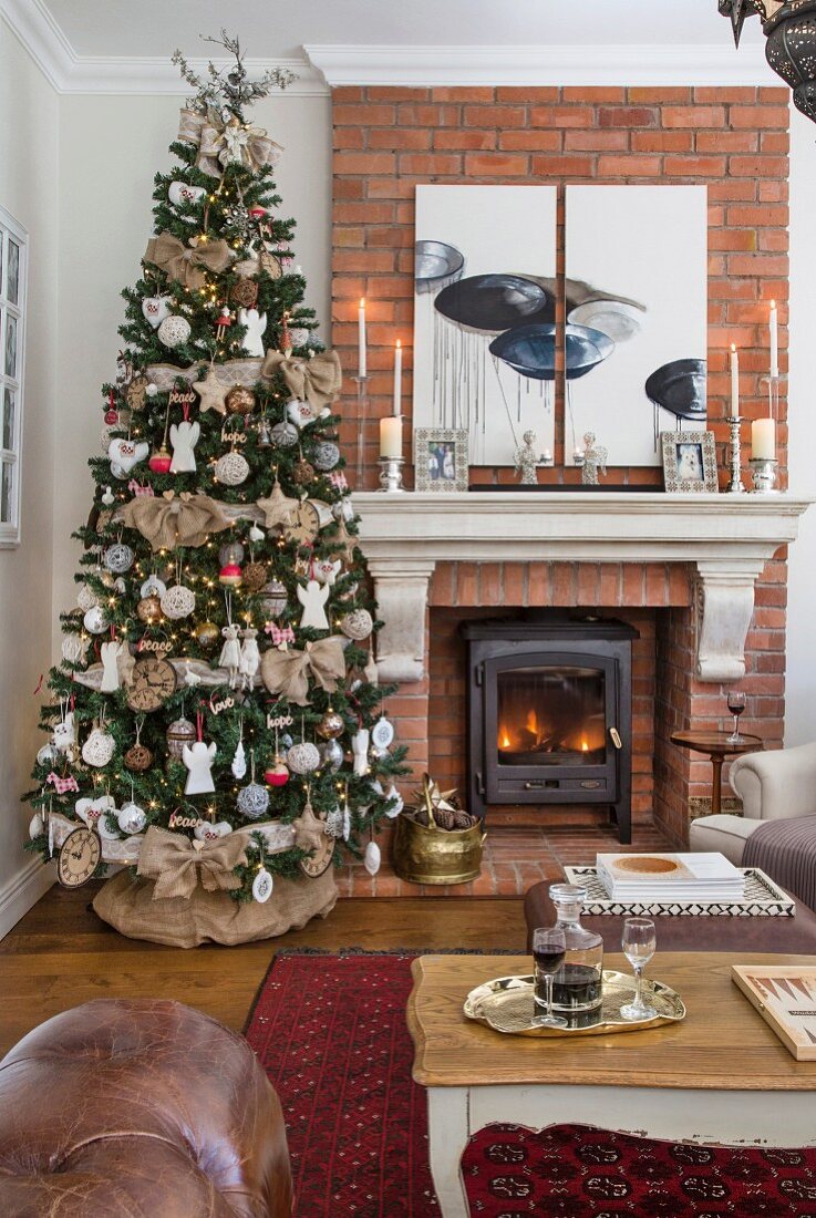 Decorated Christmas tree next to fireplace in living room