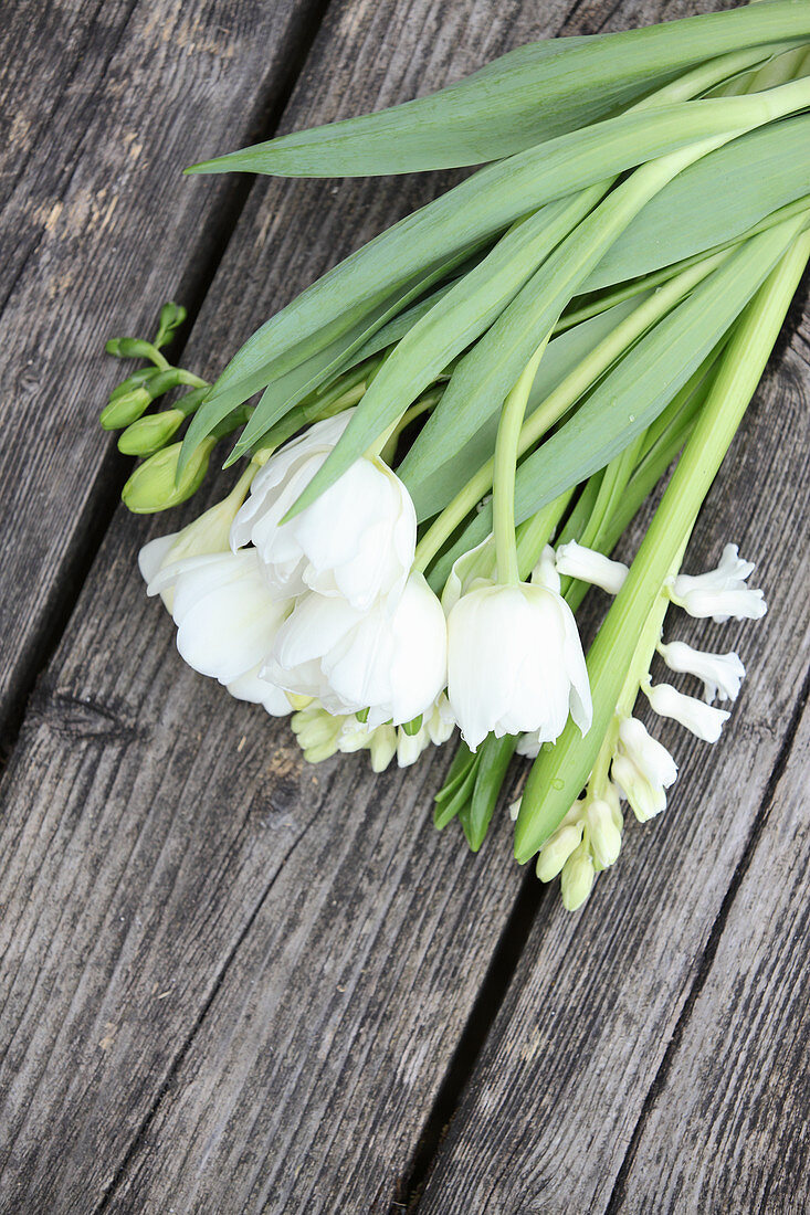 White tulips and hyacinths on weathered wooden surface