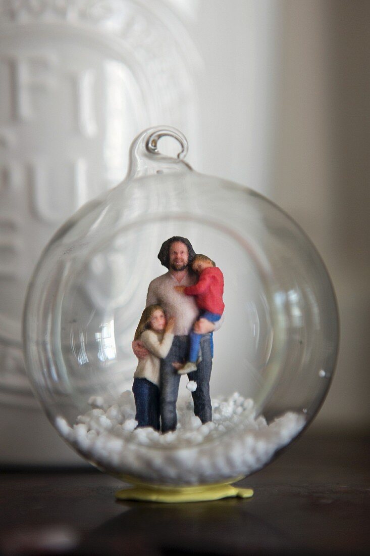 Figurines and artificial snow in glass bauble