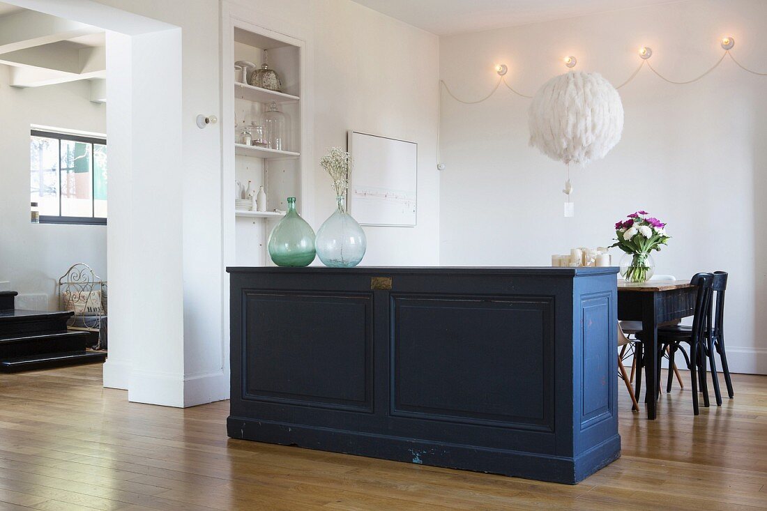 Old panelled sideboard used as partition in front of dining table