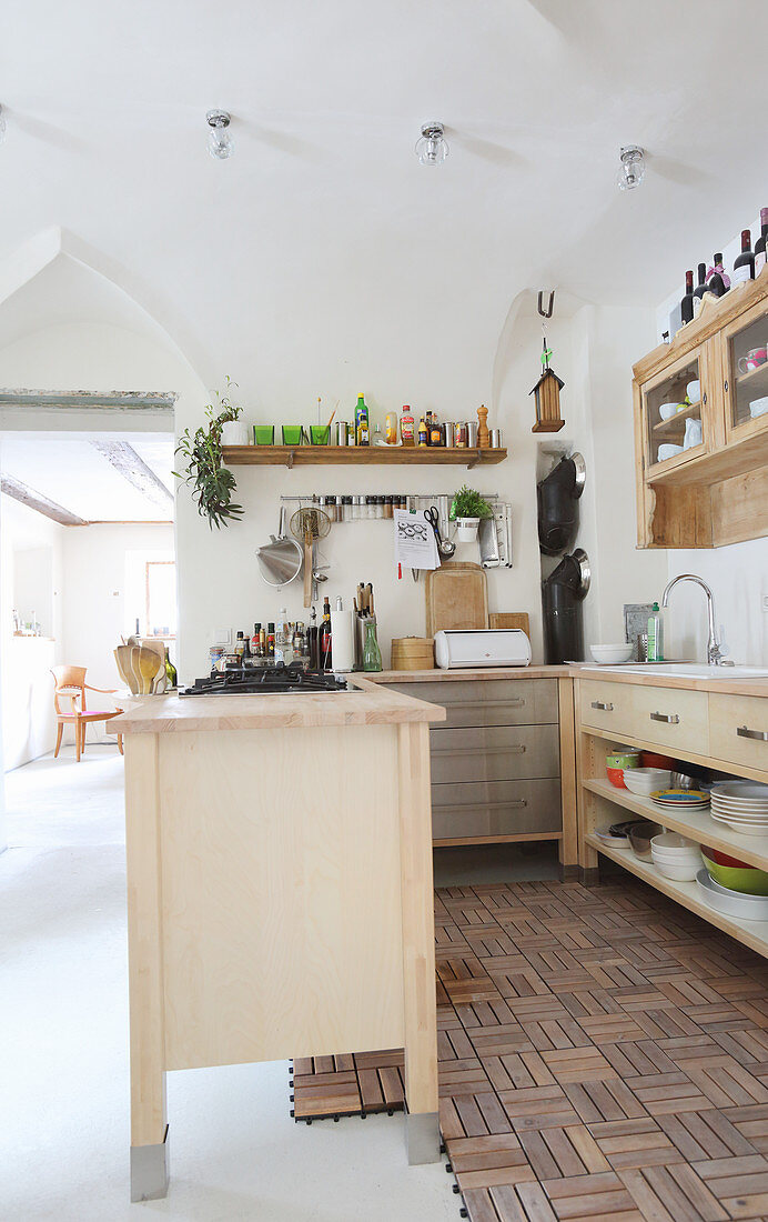 Moderne Küchenelemente auf teilweise verlegtem Holzboden