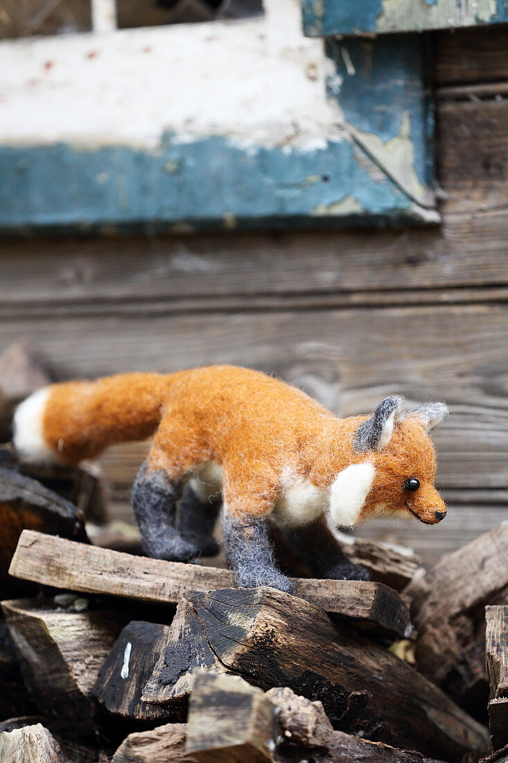 DIY-Fuchs aus Schafwolle auf Holzscheiten