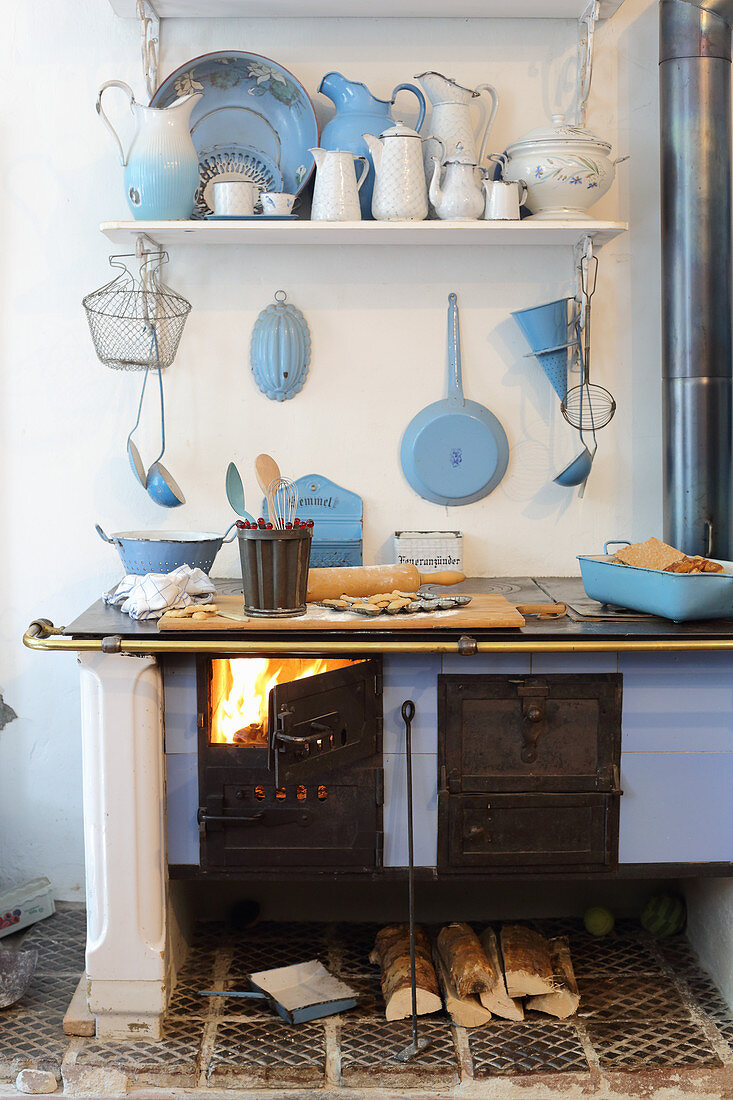Fire in wood-fired cooker and enamel kitchen utensils
