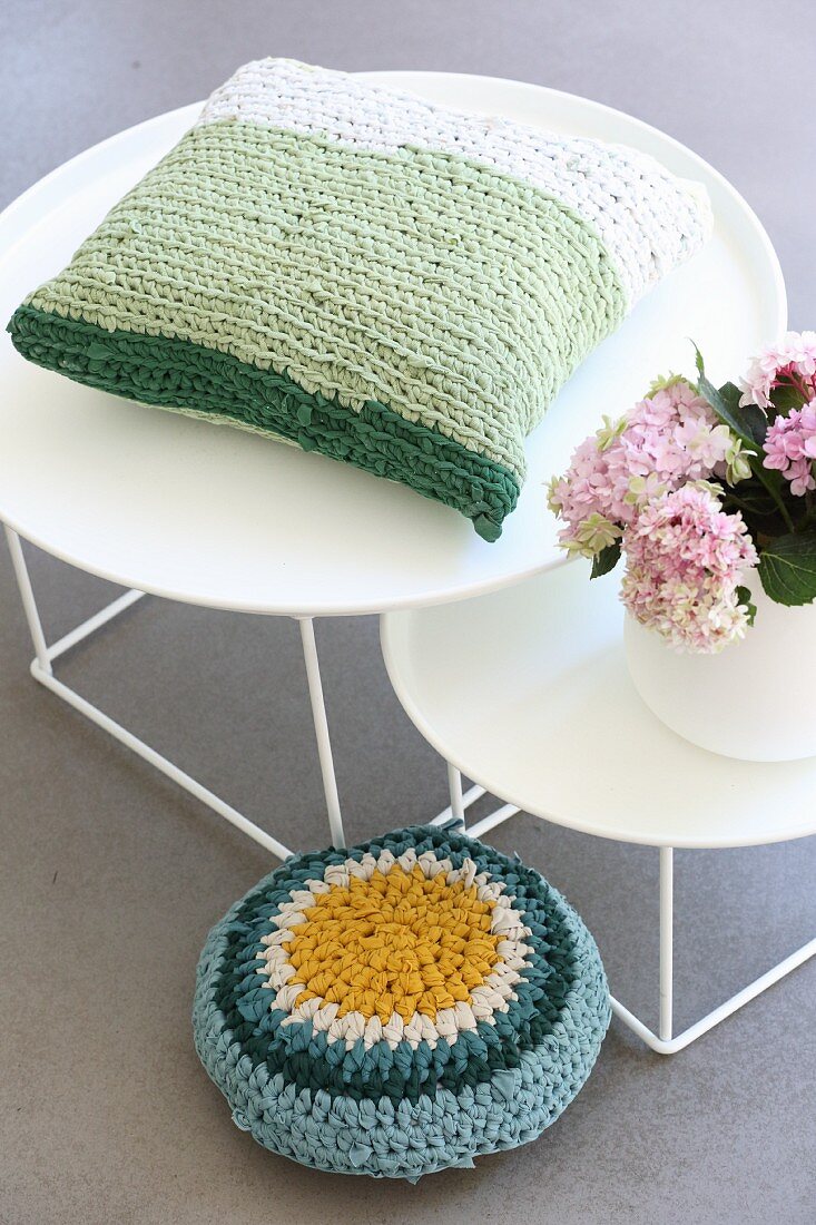 Crocheted cushion made from T-shirt yarn on round side table