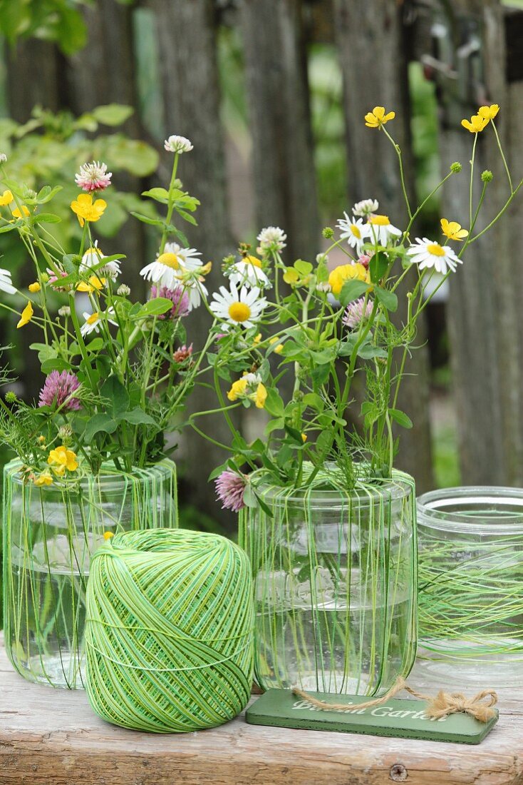Arrangement of vases, green twine and colourful wildflowers