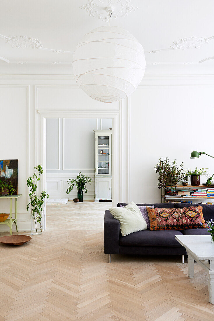 Bright living room with herringbone parquet flooring and stucco ceiling