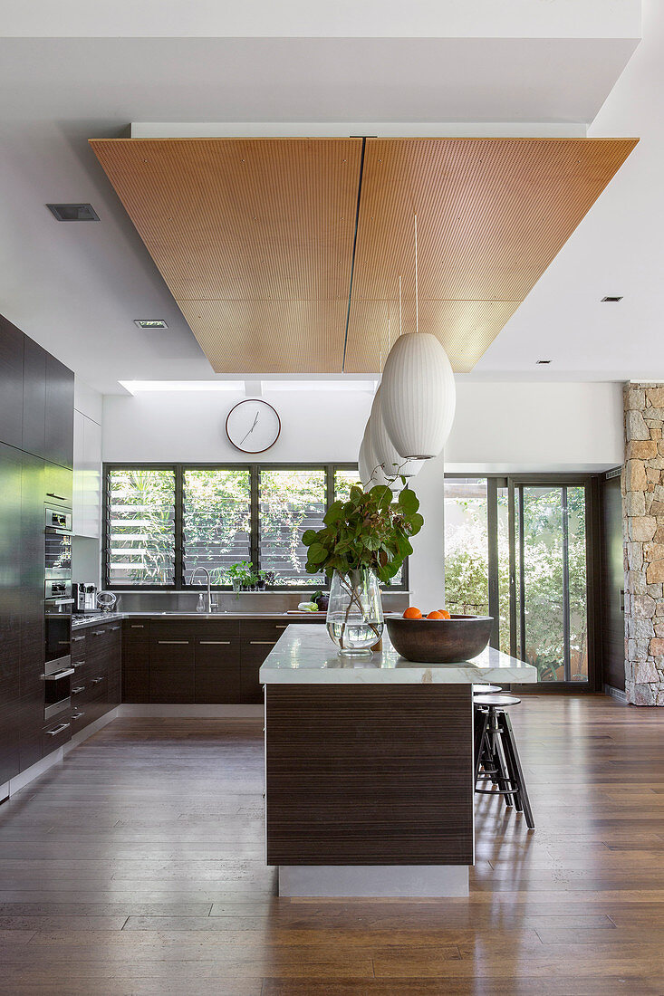 Modern open kitchen with dark wooden fronts and kitchen island
