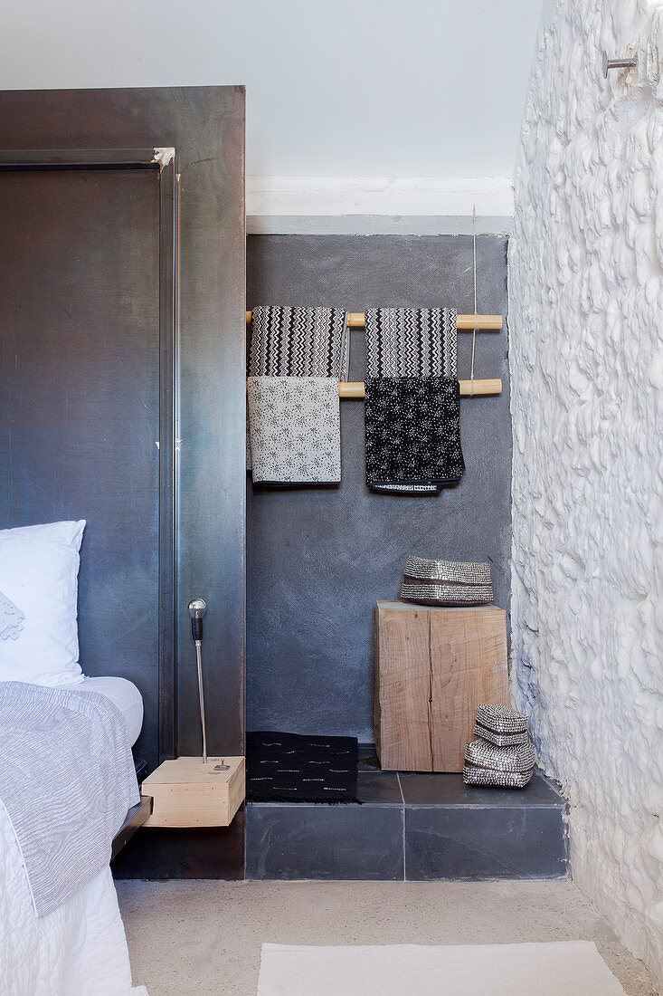 Stufe zum kleinen Bad hinter dem Bett mit schwarzer Trennwand