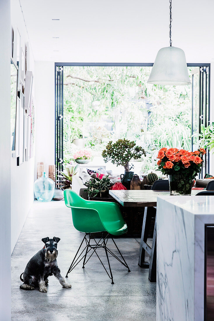 Blick auf grünen Schalenstuhl am Esstisch in offenem Wohnbereich