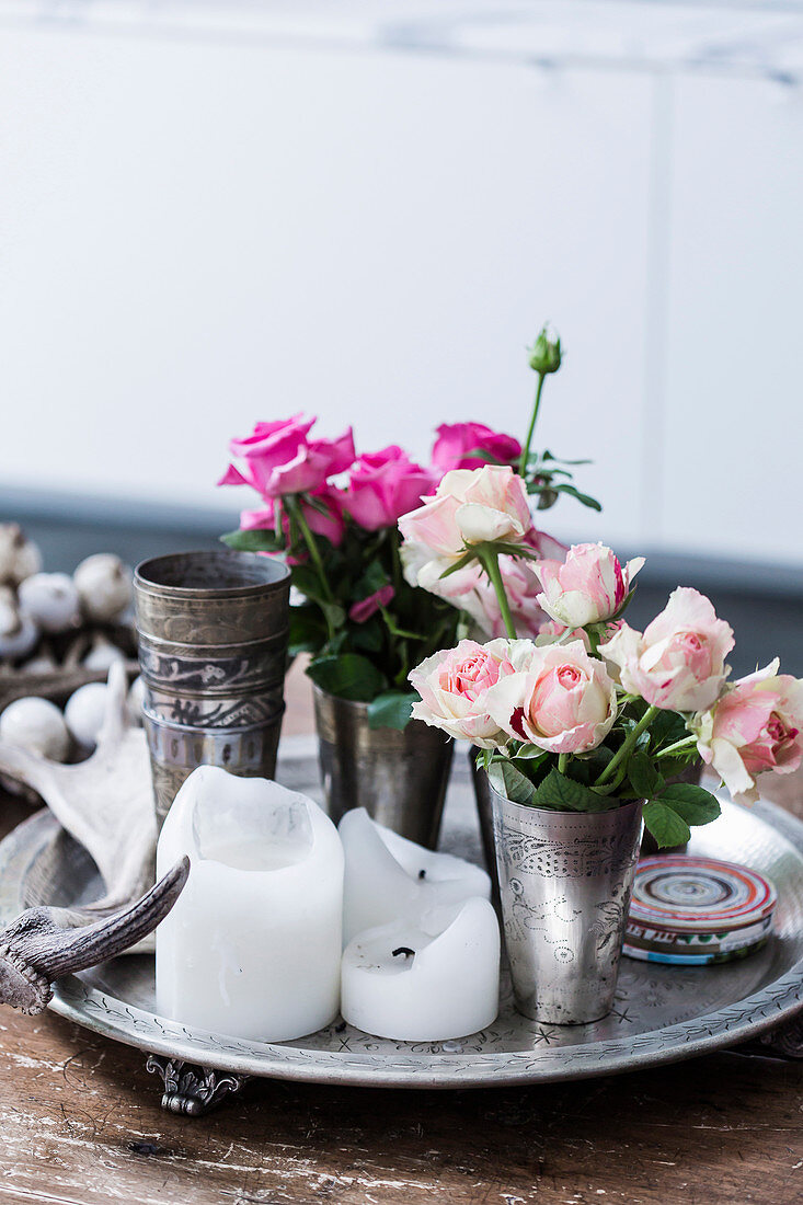 Tin cup with roses and candles on tray