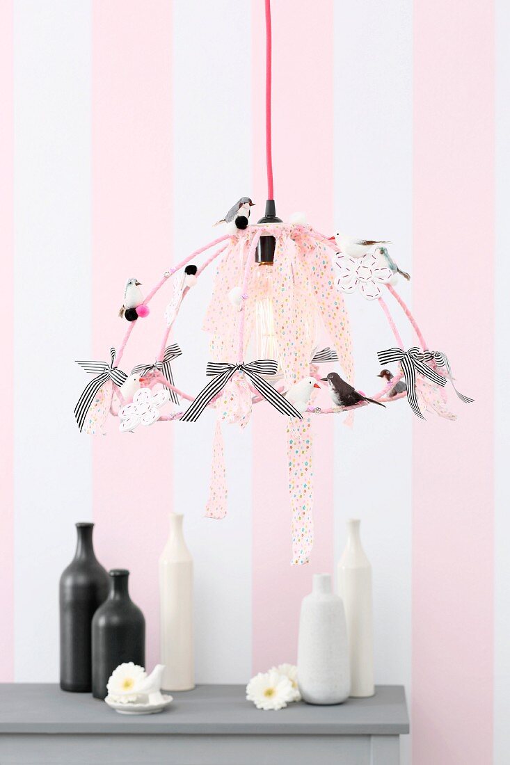 Lampenschirmgestell mit Dekovögeln und Stoffbändern dekoriert