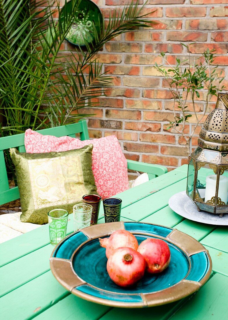 Oriental accessories on garden table against brick wall