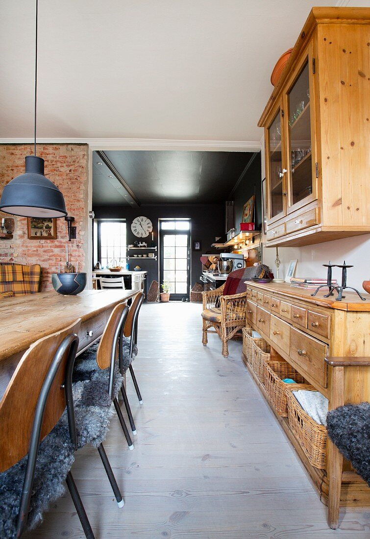 Blick vom Esszimmer mit alten Holzmöbeln in die schwarze Küche